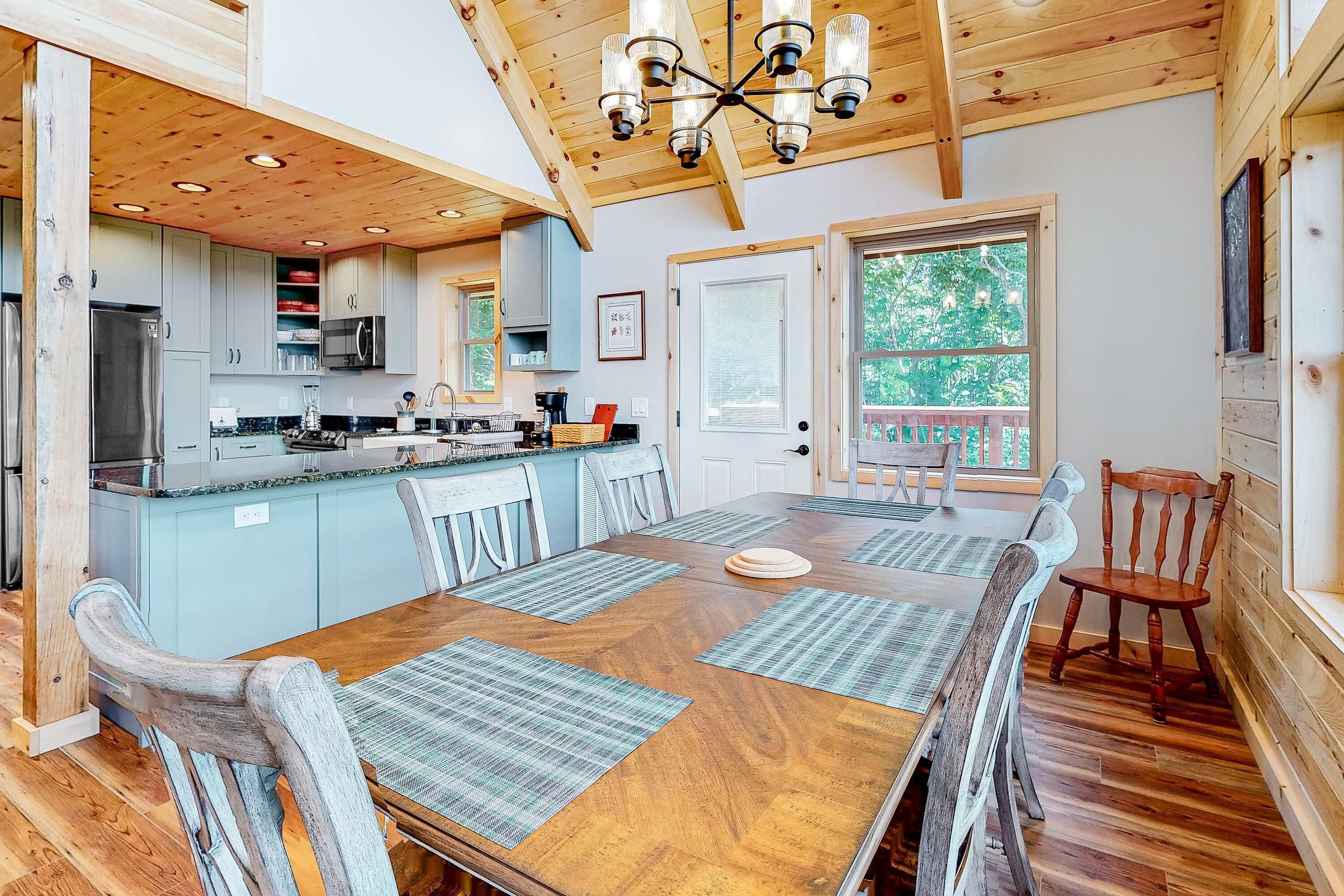 A spacious kitchen with wooden cabinets, a central island, and a dining area with a wooden table and chairs.