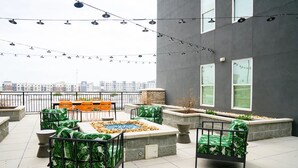 An outdoor terrace with seating, a fire pit, and string lights. - Landing | Amazing Studio, Pool, Yoga Studio (Birmingham)