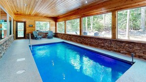 An indoor swimming pool with wooden walls and large windows. - Elegant Lodge, for 12・Pool・Hot Tub・Theater・Games (Sevierville)