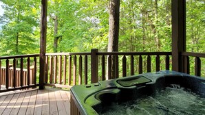 A wooden deck with a hot tub surrounded by a wooden railing, overlooking a forested area. - Mtn View Cabin, Sleeps 12・Game Room・Hot Tub・Pool (Sevierville)