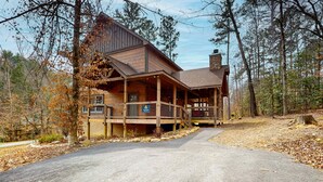 Eine Lodge mit Holzfassade, einer Veranda und einem Steinkamin.
