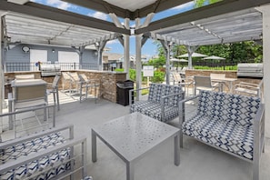 An outdoor patio with a grill, seating area, and a covered section. - Landing | Amazing 1BD, Clubhouse, Gym (Concord)