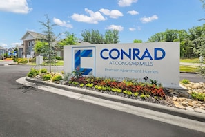 Schild für CONRAD in Concord Mills, das es als exklusive Apartmenthaus kennzeichnet.