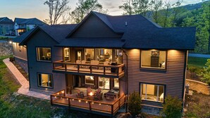 A two-story house with a balcony, large windows, and a well-lit interior. - Mtn View Home, Sleeps 8・Fireplace・Games・Hot Tub (Sevierville)
