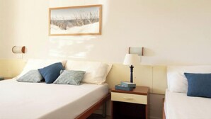Una habitación de hotel con una cama, mesitas de noche, una lámpara y un cuadro en la pared.