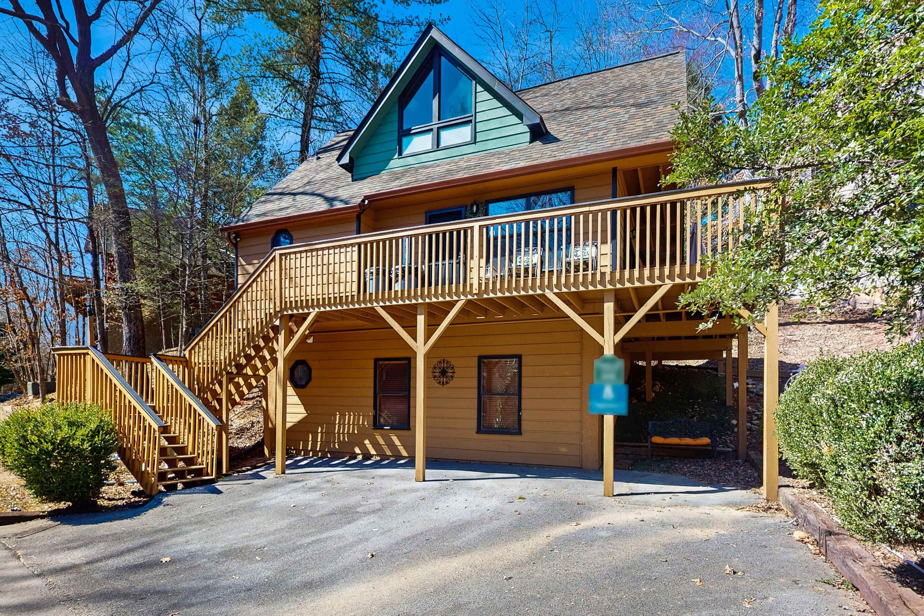 A two-story lodge with a wooden deck and a covered porch.
