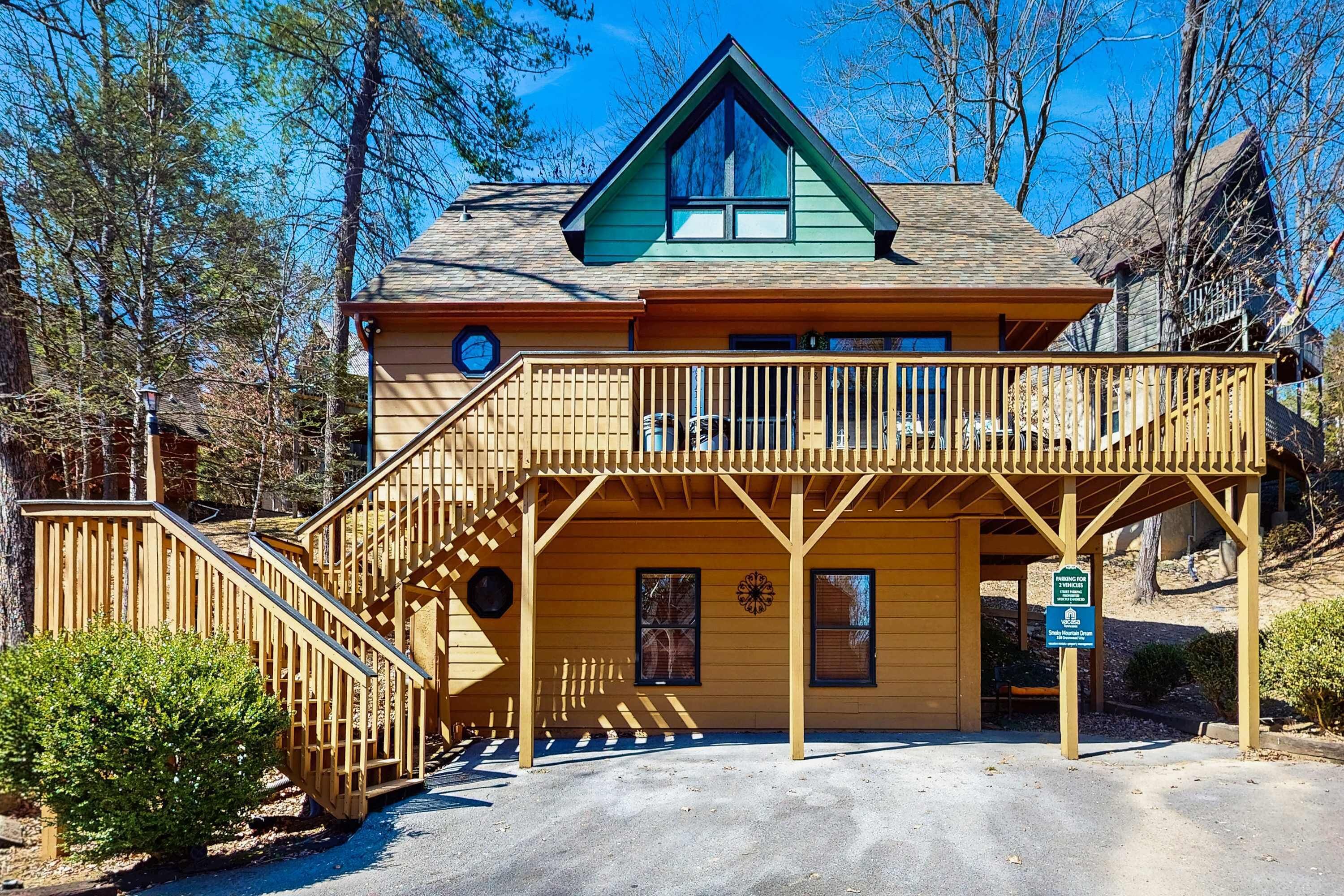 A two-story lodge with a wooden exterior, a balcony, and a staircase leading to the upper level.