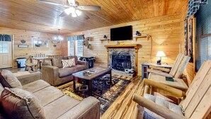 A cozy log cabin interior with a fireplace, wooden furniture, and a television. - Homey Cabin W Hot Tub・2 Porches・Pool Table・Games (Pigeon Forge)
