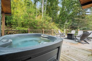 A hot tub on a wooden deck with outdoor furniture and a view of a forest. - Newly Built Mtn View Home, Sleeps 8・Hot Tub・Games (Sevierville)