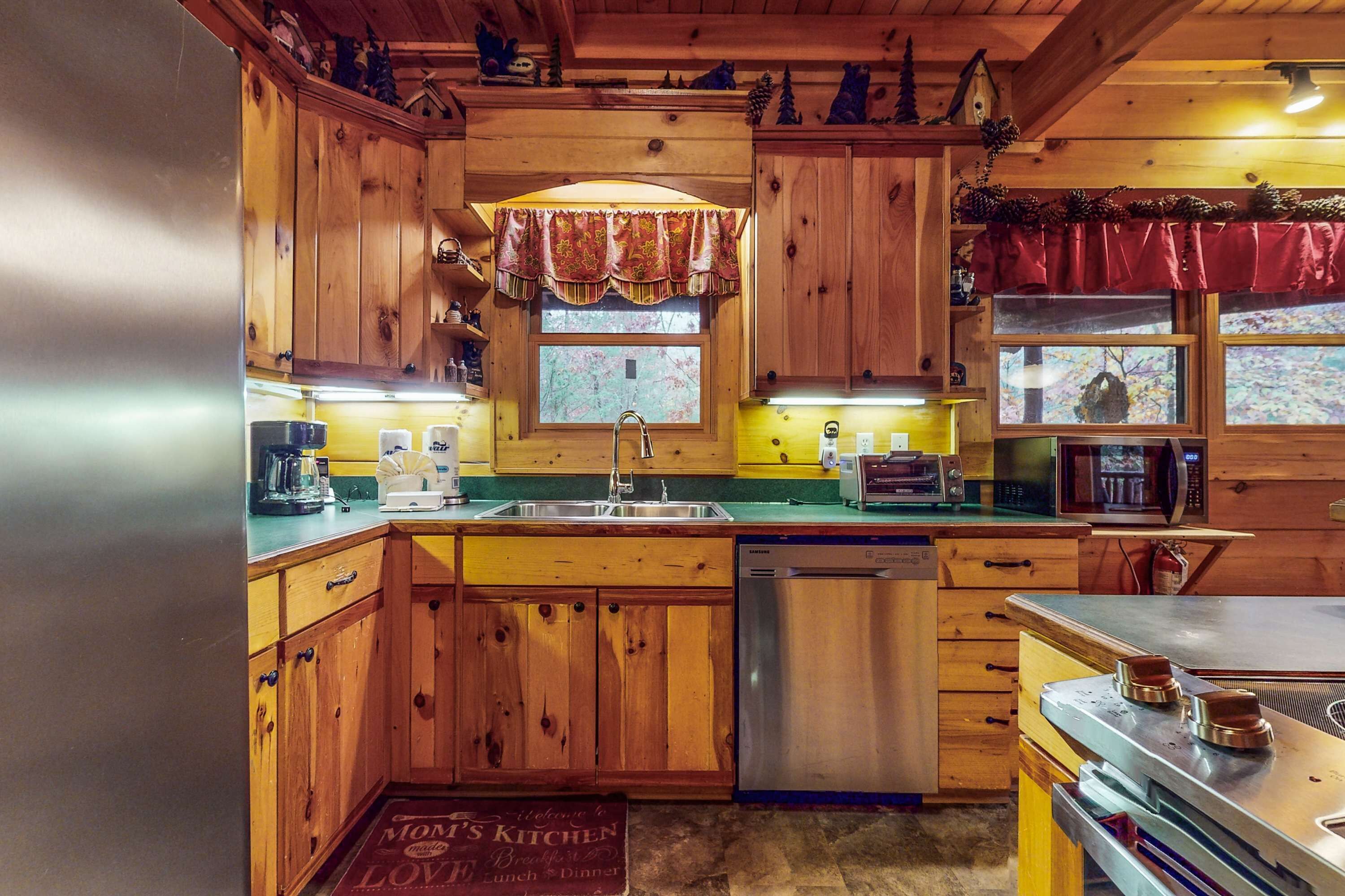 A wooden cabin-style kitchen with a sink, dishwasher, and stove.