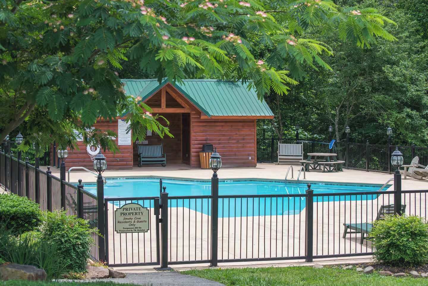 A private property with a swimming pool, wooden cabin, and outdoor seating area.