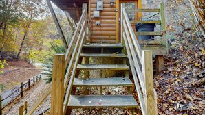 A wooden staircase leading to a cabin with a stone wall and a wooden deck. - 5 Mi to Pigeon Forge・Cozy Escape・Dog Welcome・Views (Sevierville)