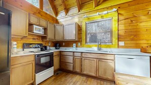 A kitchen with wooden cabinets, a microwave, a stove, and a dishwasher. - 5 Mi to Pigeon Forge・Cozy Escape・Dog Welcome・Views (Sevierville)