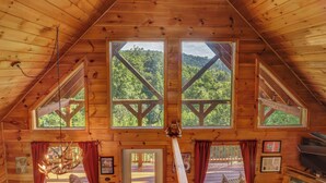 A wooden cabin with a sloped ceiling, large windows, and a chandelier. - 8.6 Mi to Dollywood・Serene Cabin Getaway・Hot Tub (Sevierville)