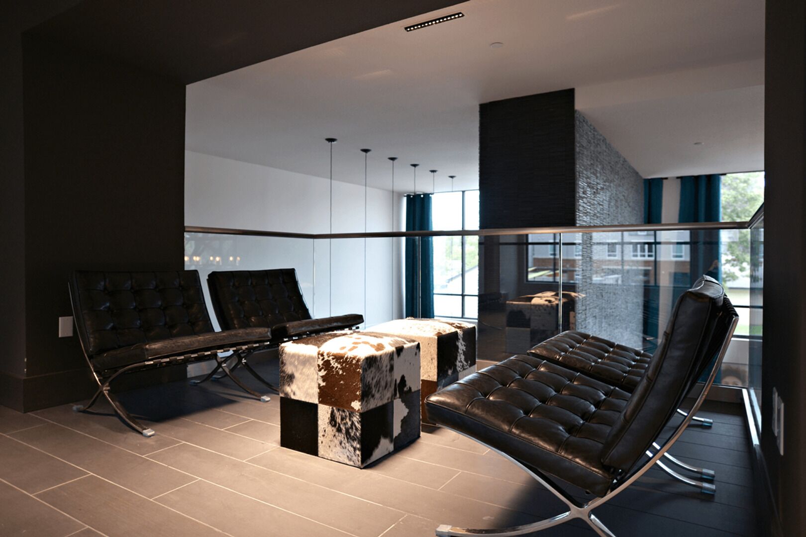 A modern lounge area with leather chairs, a unique coffee table, and large windows offering a view of the city.