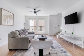A modern living room with a sofa, coffee table, and TV. - Landing | Stunning 2BD, Gym, Clubhouse (Billings)