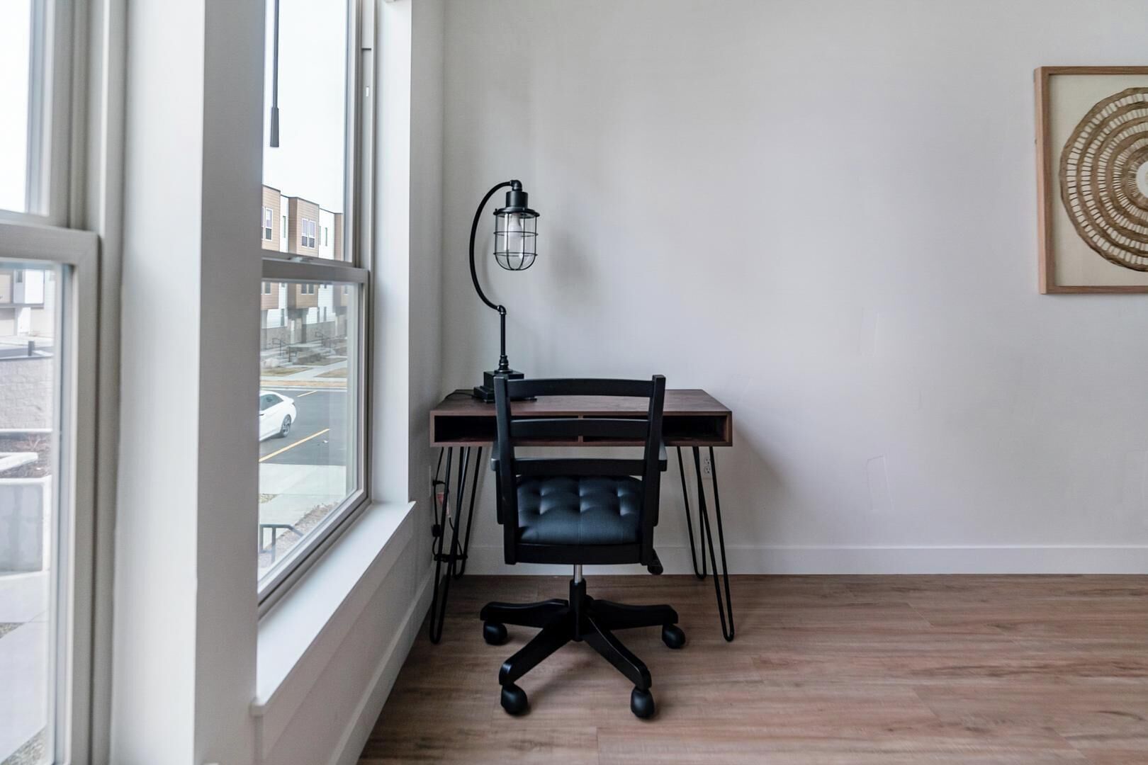 Ein Zimmer mit Schreibtisch, Stuhl und Lampe.