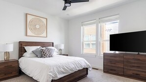 A bedroom with a bed, nightstands, a television, and a ceiling fan. - Landing | Modern 2BD, Gym, Clubhouse (Billings)