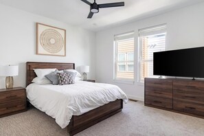A bedroom with a bed, nightstands, a television, and a ceiling fan. - Landing | Modern 2BD, Gym, Clubhouse (Billings)
