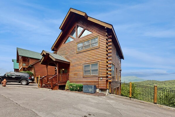 A log cabin with a steeply pitched roof, a front porch, and a view of the surrounding landscape. - 3.5 Mi to DT Pigeon Forge Stay・Hot Tub・Grill・Games (Pigeon Forge)