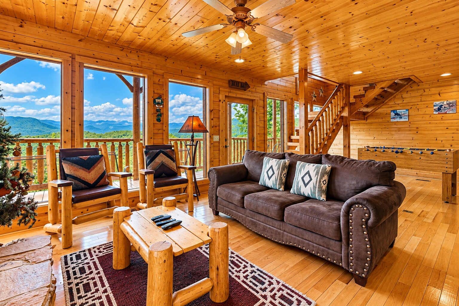 A wooden interior with a sofa, chairs, a table, and a view of the outdoors.