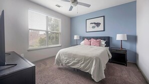 A bedroom with a bed, two bedside tables with lamps, a ceiling fan, and a window with blinds. - Landing | Beautiful 1BD, Gym, Clubhouse (Nashville)