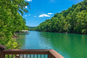 A river with a boat docked on the left, surrounded by lush green trees. - Waterfront Retreat, Sleeps 14, Theater, Games, Grill (Maynardville)