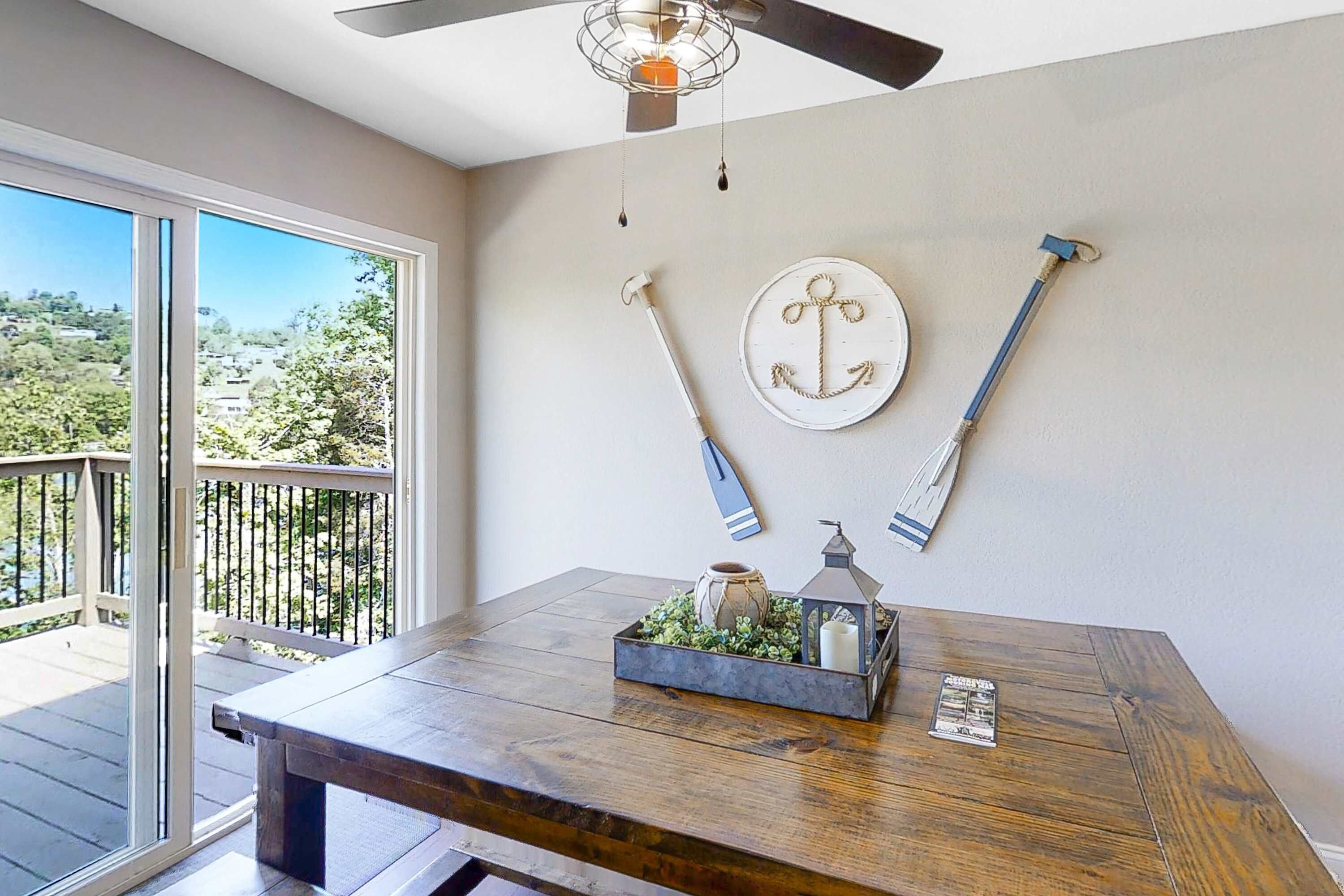 Dining space with large table and sliding doors to the deck. Ideal for meals and gatherings; easy indoor/outdoor flow, lake views, and bright natural light for family vacations and group stays.
