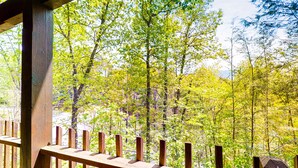 A wooden deck with a view of a forested area. - Gatlinburg Cabin W Hot Tub・Jacuzzi Tub・Seelsp 4 (Gatlinburg)