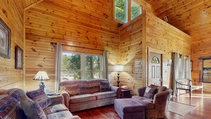 A log cabin interior with a wooden floor, a sofa set, a chair, and a lamp. - Centrally Located Cabin, Sleeps 6・Pool Table・Views (Gatlinburg)