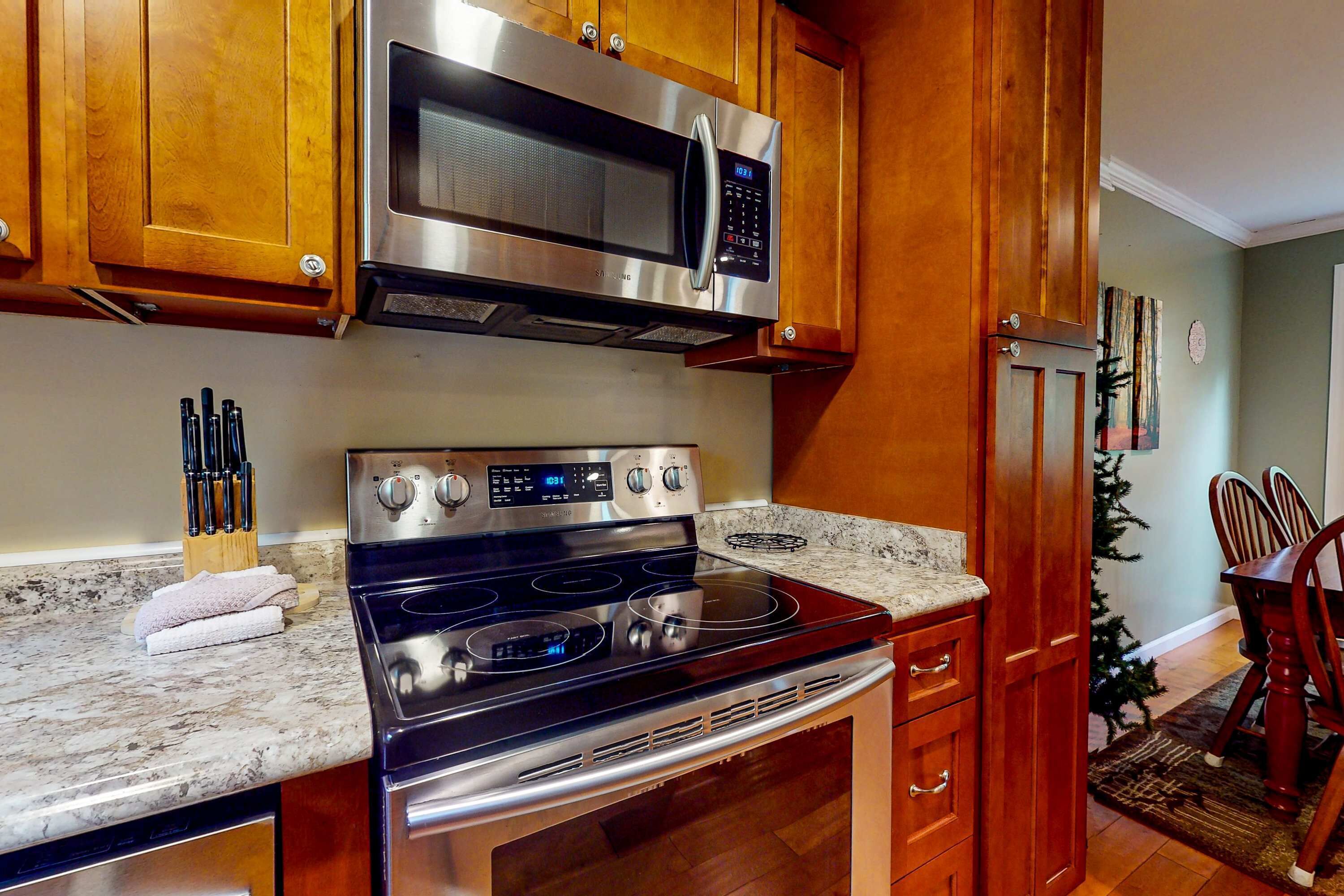 A kitchen with wooden cabinets, stainless steel appliances, and a granite countertop.