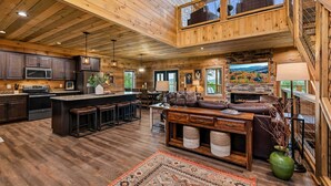 A spacious kitchen with a central island, a cozy seating area with a fireplace, and a view of the outdoors. - Spacious Scenic Cabin, Sleep 12, Games, Hot Tub, View (Sevierville)