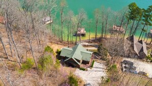 A house with a green roof, surrounded by trees and a body of water. - Family-Friendly Big Creek Getaway・Hot Tub・Firepit (LaFollette)