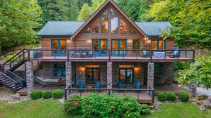 A log cabin with a balcony, outdoor seating, and a staircase. - Family-Friendly Big Creek Getaway・Hot Tub・Firepit (LaFollette)