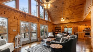 A spacious cabin interior with a large living area, wooden walls, and a kitchen. - Family-Friendly Big Creek Getaway・Hot Tub・Firepit (LaFollette)