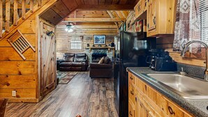 Ein Holzblockhaus Innenansicht mit Küche, Essbereich und Wohnzimmer.