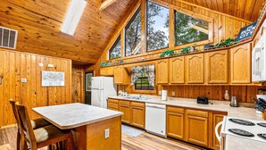 A kitchen with wooden cabinets, a white refrigerator, a dishwasher, and a stove. - Always Delightful - Sleeps 10, Hot Tub, Fire pit, Games (Sevierville)
