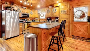A wooden cabin kitchen with a stainless steel refrigerator, microwave, and coffee maker. - 3.5 Mi to DT Pigeon Forge・Dog Ok! Getaway・Hot Tub (Pigeon Forge)