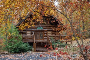A log cabin with a wooden staircase leading to a front door, surrounded by autumn foliage. - Pet Friendly Near Dollywood Cabin・Hot tub・Views (Sevierville)