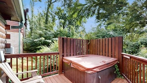 A wooden deck with a hot tub, a chair, and a wooden fence. - 2 Mi to DT PIgeon Forge・Serene Stay・Hot Tub・Grill (Pigeon Forge)