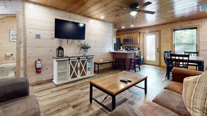 A wooden cabin interior with a living room, kitchen, and dining area. - 2 Mi to DT PIgeon Forge・Serene Stay  ・Hot Tub・Grill (Pigeon Forge)