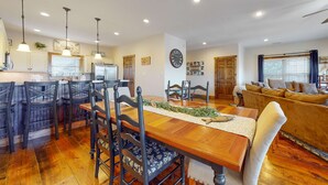 A spacious living area with a wooden dining table, chairs, and a sofa. - Spacious Norris Lake Retreat・View・Deck・BBQ Grill (Andersonville)