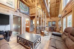 A log cabin interior with a dining area, a sofa, and a TV. - Dog Ok・Lakefront Cabin Stay・Fire Pit・Private Dock (LaFollette)
