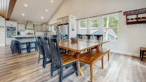 Una cocina amplia con electrodomésticos modernos, una gran mesa de comedor y vistas al exterior.