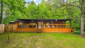 Eine Holzhütte mit Veranda, einer Tür und einer kleinen Treppe, die zum Eingang führt.