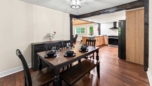 Ein Essbereich mit Holztisch und Stühlen, einem Deckenventilator und Blick zur Küche.