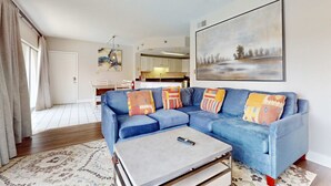 A living room with a blue sofa, a coffee table, and a painting on the wall. - Riverfront Retreat・1 mile to Pigeon Forge・Pool (Pigeon Forge)