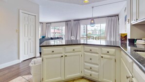A kitchen with white cabinets, a granite countertop, and a view of the outside. - Riverfront Retreat・1 mile to Pigeon Forge・Pool (Pigeon Forge)