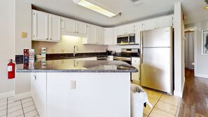 A modern kitchen with white cabinets, stainless steel appliances, and a granite countertop. - Riverfront Retreat・1 mile to Pigeon Forge・Pool (Pigeon Forge)