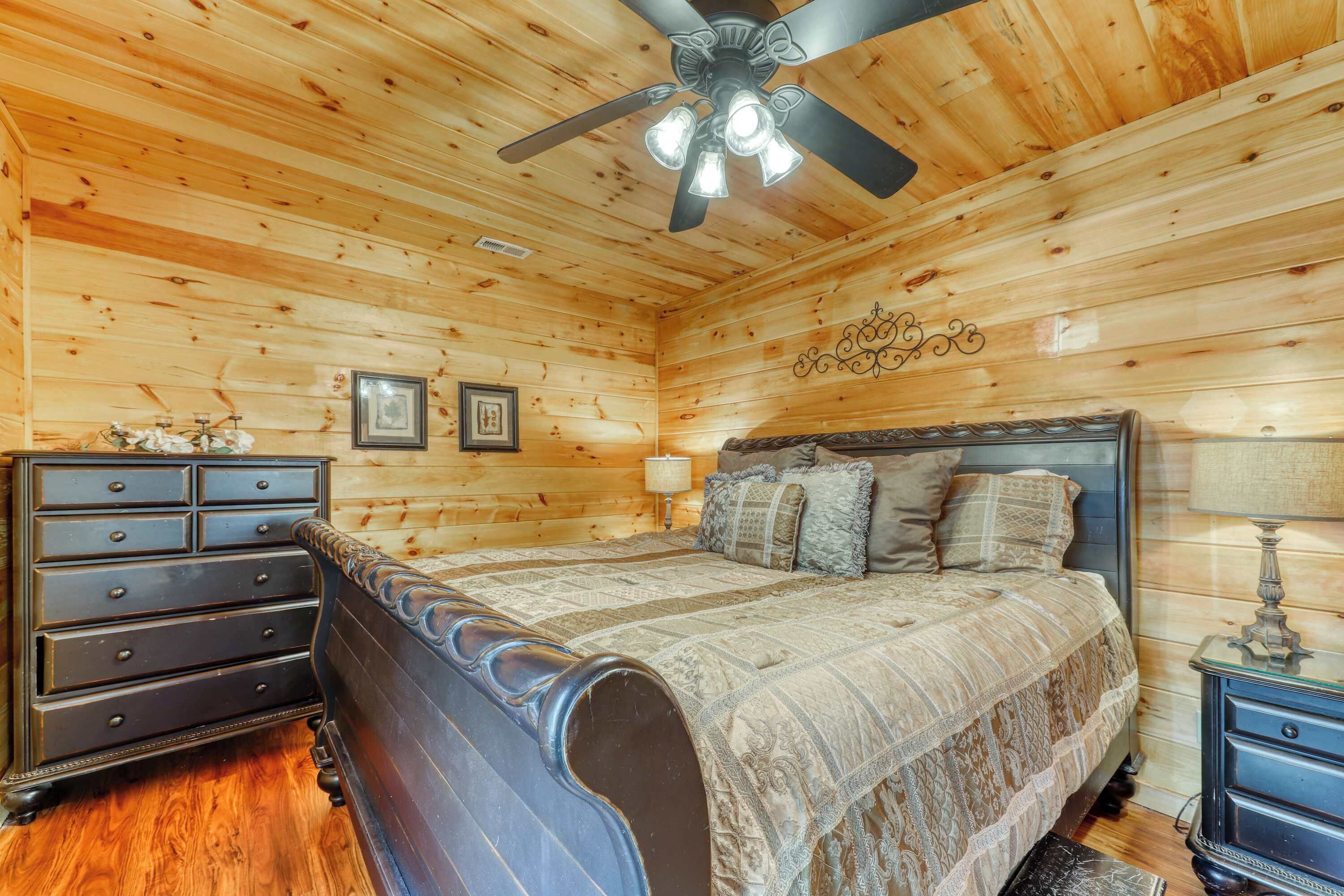 Un dormitorio con paneles de madera, una cama, un aparador y mesitas de noche.